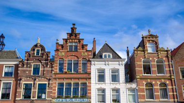 Güneşli bir günde Hollanda'nın Delft şehrinde sokaklar boyunca mimari.