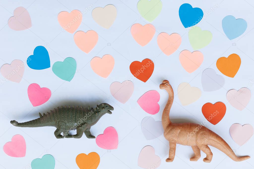 Two dinosaurs on the background of colorful hearts. Concept of Valentine's Day.