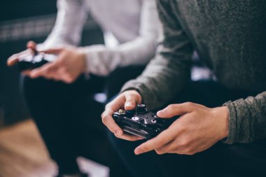 Bir video oyun konsolu olan Microsoft Xbox için siyah oyun kumandası tutan genç bir adam.