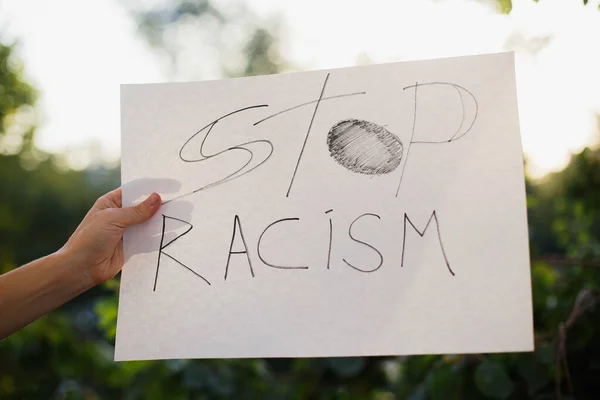 Woman Holding White Paper Text Stop Racism Background Trees Sunlight — Stock Photo, Image