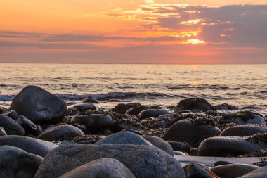 Unstad sahilde günbatımı Lofoten Norveç'te dağlarda çevrili