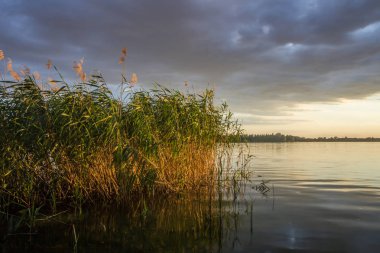 gün batımı ve göl üzerinde kara bulutlar