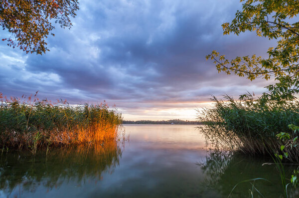 sunset and dark clouds over the lake