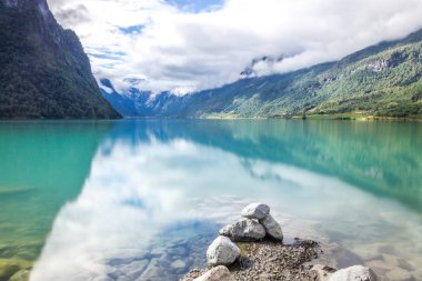 Norveç'te dağlarda Oldenvatnet gölü üzerinde bulutlar ve taşlar