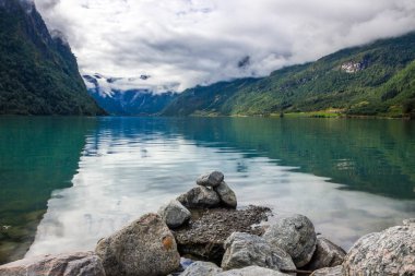 Norveç'te dağlarda Oldenvatnet gölü üzerinde bulutlar ve taşlar