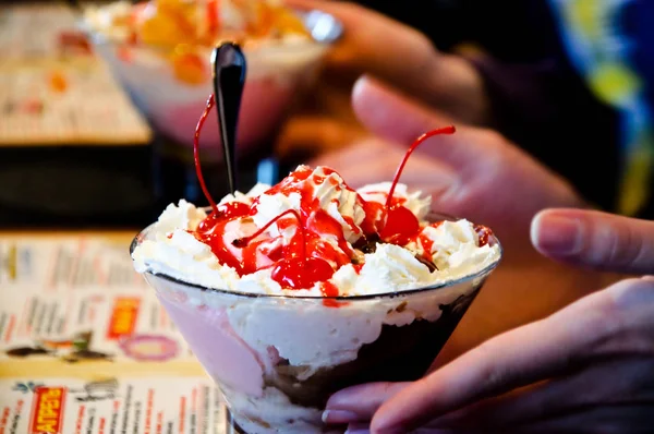 美味的甜樱桃冰淇淋与张开的手和勺子 — 图库照片