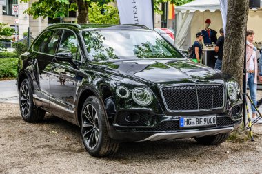 Baden Baden, Almanya - Temmuz 2019: Siyah Bentley Bentayga geçiş aracı 2015, Kurpark 'ta yaşlılar toplantısı