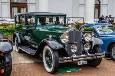 Baden Baden, Almanya - Temmuz 2019: Koyu yeşil Packard De Luxe Sekiz 904 Sedan Limuzin 1932, Kurpark 'ta yaşlı adam toplantısı