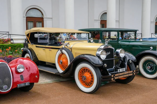 БАДЕН-БАДЕН, ГЕРМАНИЯ - ИЮЛЬ 2019: Желто-бежевый PACKARD PHAETON MODEL 640 cabrio roadster 1929, встреча старожилов в Курпарке Стоковое Фото