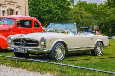 Baden Baden, Almanya - Temmuz 2019: beyaz bej Mercedes 280 Sl Pagode W113 1963 1971 Cabrio, Kurpark 'ta yaşlı adam toplantısı
