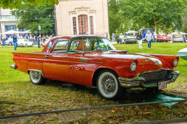 Baden Baden, Almanya - Temmuz 2019: kırmızı turuncu Ford Thunderbird ilk nesil coupe 1955 1957, Kurpark 'ta yaşlılar toplantısı