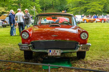 Baden Baden, Almanya - Temmuz 2019: kırmızı turuncu Ford Thunderbird ilk nesil coupe 1955 1957, Kurpark 'ta yaşlılar toplantısı