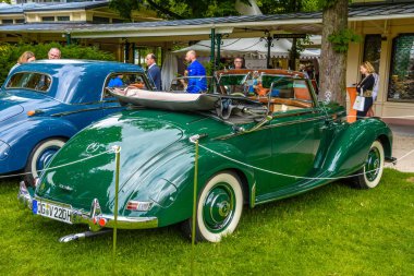 Baden Baden, Almanya - Temmuz 2019: yeşil Mercedes-Benz 220 Cabriolet Bir Cabrio Roadster W187 1951 1955, Kurpark 'ta yaşlı adam toplantısı