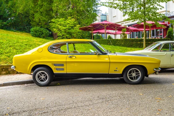 БАДЕН-БАДЕН, ГЕРМАНИЯ - ИЮЛЬ 2019: жёлтый черный FORD CAPRI MK I 2800 1969 1974 спортивное купе, встреча старшеклассников в Курпарке Стоковая Картинка