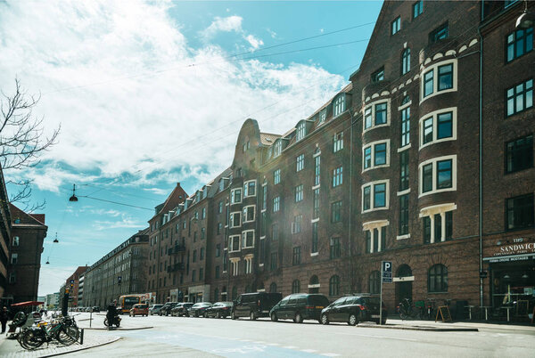 COPENHAGEN, DENMARK - MAY 5, 2018: urban scene with cloudy sky, city street and buildings in copenhagen, denmark