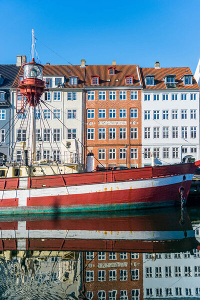 COPENHAGEN, DENMARK - 06 MAY, 2018: boat and houses reflected in water at Nyhavn pier, copenhagen, denmark