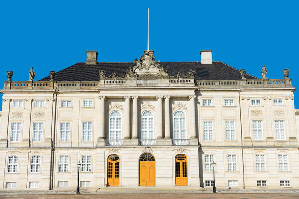 beautiful architecture of historical Amalienborg castle with columns and statues in copenhagen, denmark