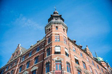 low angle view of building against bright blue sky in Copenhagen, Denmark clipart