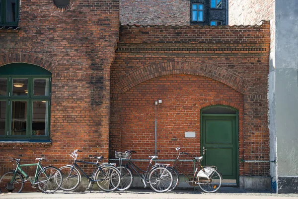 parked bicycles near brick wall of building of Copenhagen, Denmark