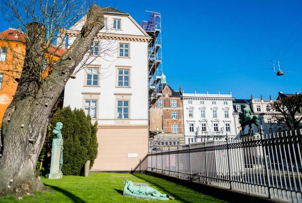 Estatua en césped verde entre árboles y casas modernas en la calle en Copenhagen - foto de stock