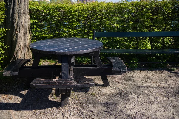Mesa de madera redonda vacía con bancos en el parque, copenhagen, denmark - foto de stock