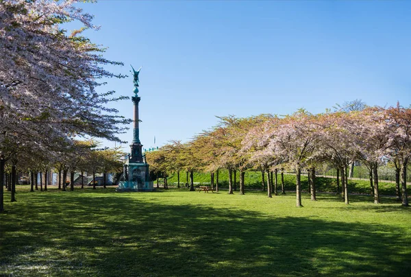 Monumento entre belas árvores florescendo no parque, copenhagen, denmark — Fotografia de Stock