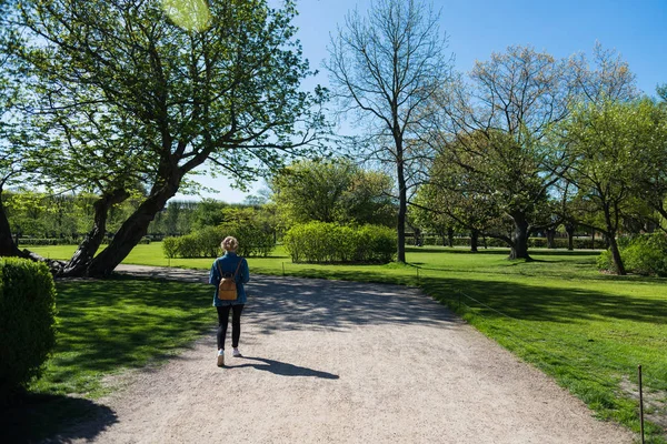Back view of young woman walking in beautiful park in copenhagen, denmark — Stock Photo