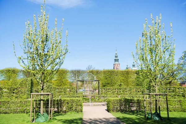 Beautiful park with blossoming trees and green bushes and Rosenborg castle in Copenhagen, Denmark — Stock Photo