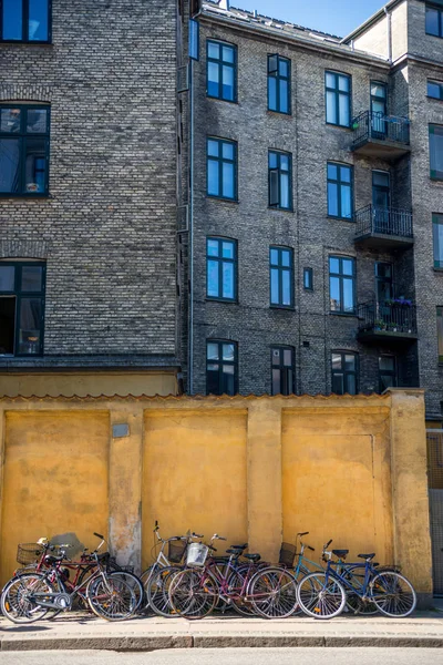 Bâtiment et vélos garés près du mur de pierre jaune à Copenhague, Danemark — Photo de stock