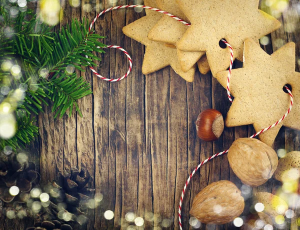 クリスマスのクッキー クルミ ナッツ マツ円錐形 木製の背景上のモミの枝 — ストック写真