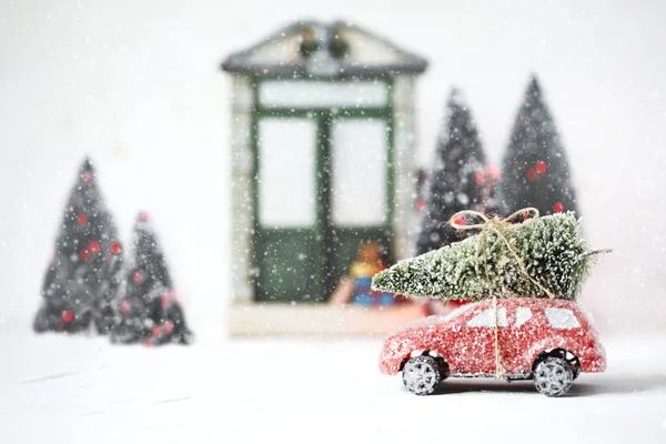 Red retro toy car delivering Christmas Tree. Holiday card