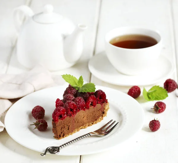巧克力蛋糕与新鲜覆盆子在白色盘子与茶杯 — 图库照片