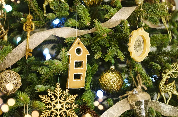 Christmas green tree with golden decorations, close-up