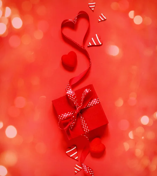 Κουτί δώρου με κόκκινο φιόγκο κορδέλα σε κόκκινο φόντο για του Αγίου Βαλεντίνου da — Φωτογραφία Αρχείου