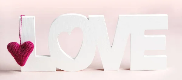 Word Love and pink hearts at pink background
