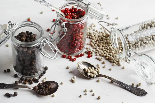 Pink, white and black peppers in a glass jars — Stock Photo, Image