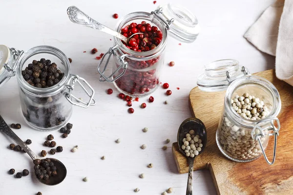 Pink, white and black peppers in a glass jars — Stock Photo, Image