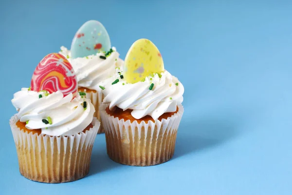 Easter vanilla cupcakes on blue background — Stock Photo, Image