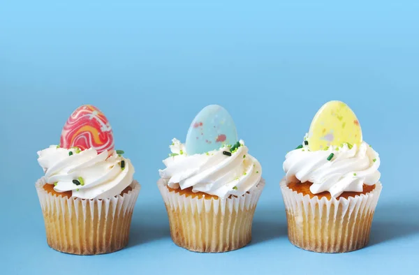 Easter vanilla cupcakes on blue background — Stock Photo, Image