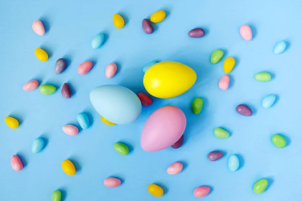 Osterdeko-Eier und Bonbons auf blauem Hintergrund. Ostern zurück — Stockfoto