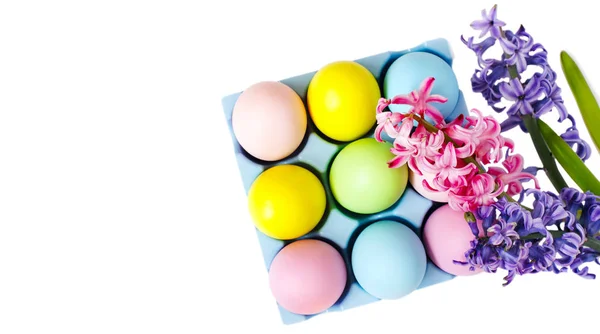 Pasqua uova colorate e fiori su sfondo bianco, spazio copia — Foto Stock