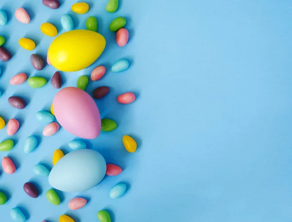 Osterdeko-Eier und Bonbons auf blauem Hintergrund. Ostern zurück — Stockfoto