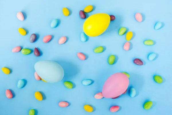 Osterdeko-Eier und Bonbons auf blauem Hintergrund. Ostern zurück — Stockfoto
