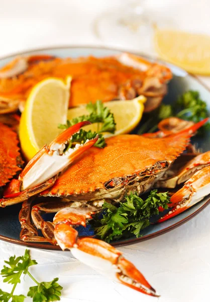 Kokta krabbor serveras på tallrik med citron och persilja. — Stockfoto