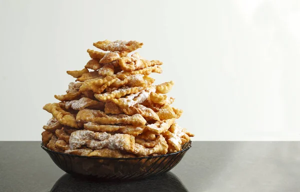 Des beignets saupoudrés de sucre glace. Frappe ou chiacchière. Tradit — Photo