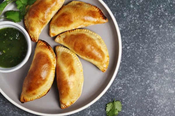 Empanadas z sosem chimichuri. Tradycyjne latynoamerykańskie plików CUI — Zdjęcie stockowe