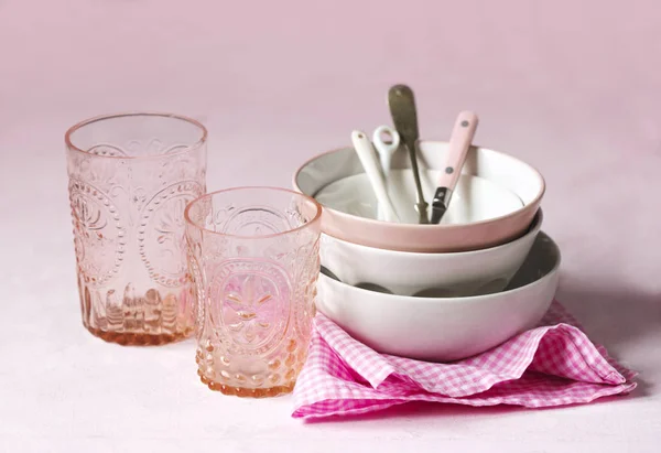 Üres rózsaszín és fehér tálak, poharak és konyhai eszközök. — Stock Fotó