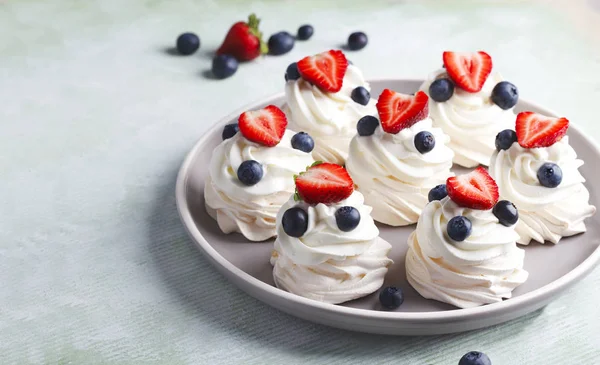 Mini merengue Pavlova con crema batida y bayas . — Foto de Stock