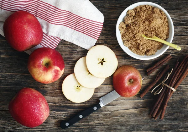 Яблоки, груши, коричные палочки и коричневый сахар на деревянной спине — стоковое фото