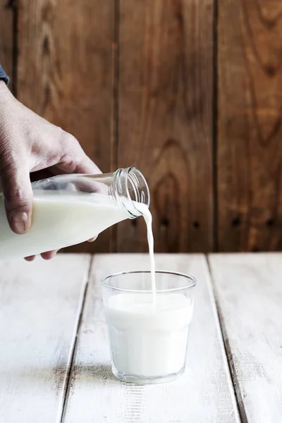 Verser le lait à la main dans du verre. Concentration sélective — Photo